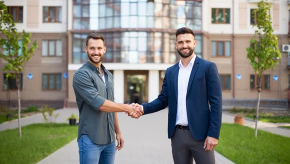 Two Property Managers shaking hands outside an apartment complex where they have valet trash service